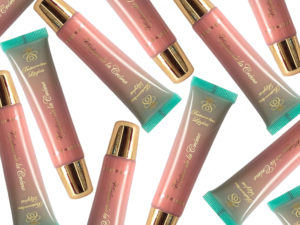 a petal pink lip gloss with warm undertones in a squeeze tube with gold cap