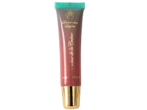 peach lip gloss in squeeze tube with gold cap on white background