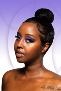 Beautiful African woman with long eyelashes, lip gloss and purple eyeshadow on purple background.