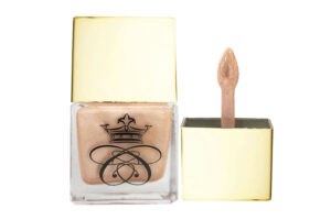 liquid highlighter in glass bottle with gold cap and wand applicator on white background