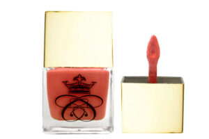 liquid blush in glass bottle with gold cap and wand applicator on white background