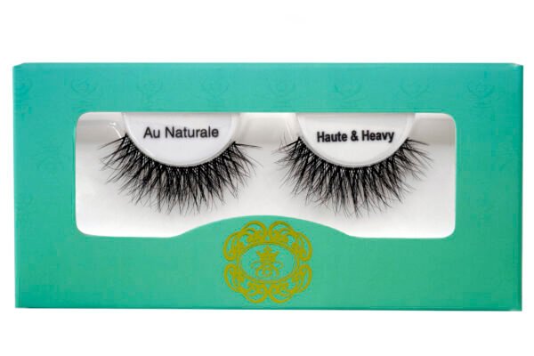 Haute & Heavy Biodegradable Eyelashes black strip eyelashes in gradient blue-green eyelash box on white isolated background.