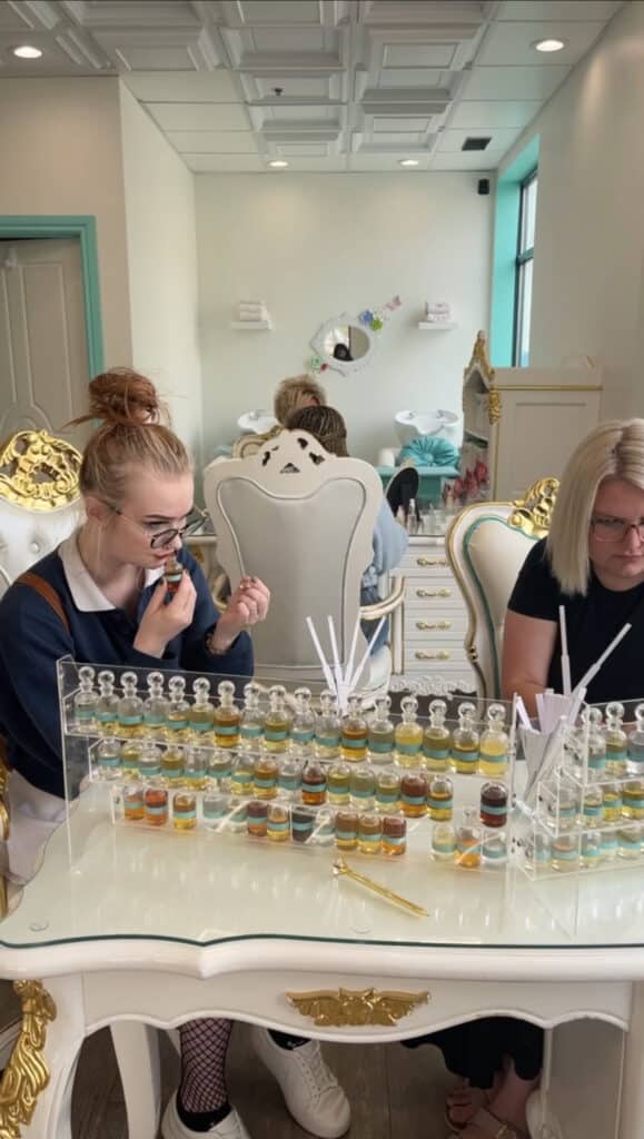 women sitting at perfumer's organ smelling fragrance notes to create bespoke perfume Crème de la Crème Beauty Lounge